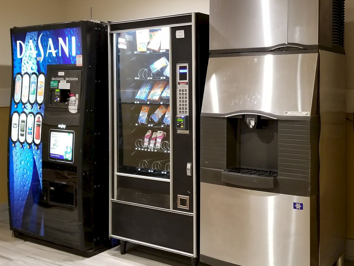 The image shows three machines: a vending machine for bottled water, a snack vending machine, and an ice dispenser.