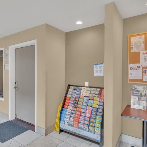 The image shows an indoor area with informational pamphlets and a bulletin board on the wall. There’s a nearby door and tiled flooring.